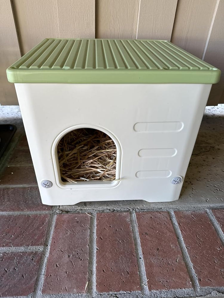 Small animal house with a green lid on a brick surface