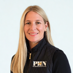 Woman wearing a black quilted vest with a logo on a light gray background