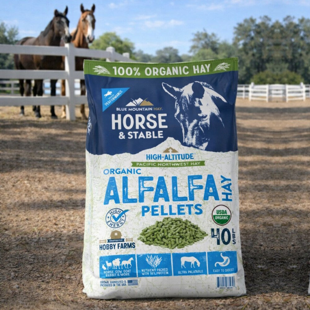 Bag of Blue Mountain Hay Organic Alfalfa Pellets for horses with two horses in the background.