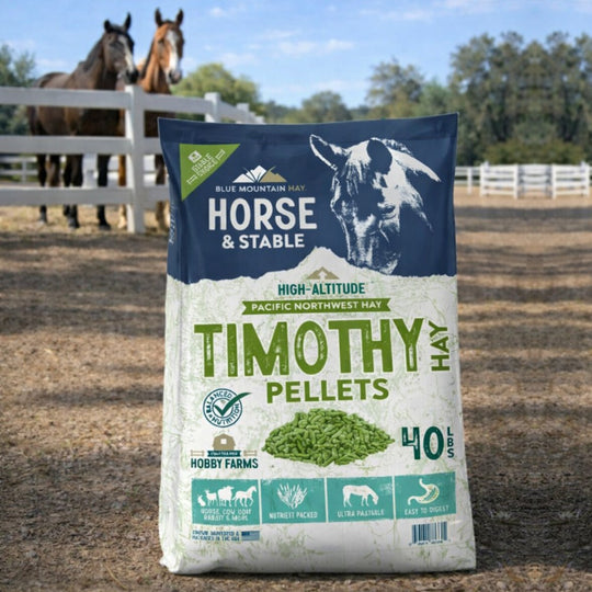 Bag of Timothy Hay Pellets for horses with two horses in the background.